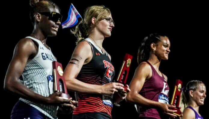 Transgender athlete Camden Schreiner holding his medal.