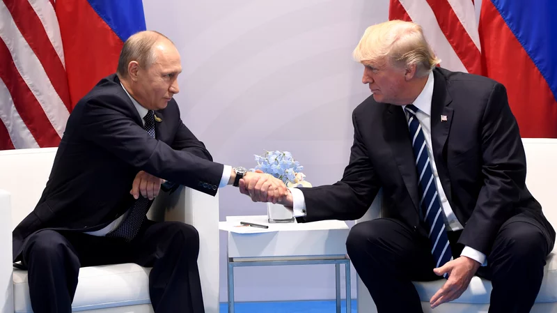 Putin shakes the hand of President Trump in 2018.